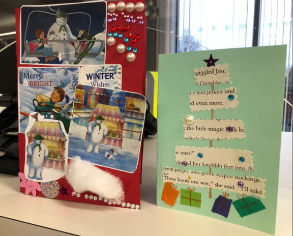 Two handmade Christmas cards on display in a library