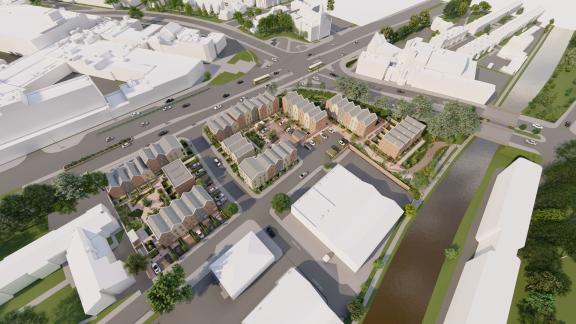 Aerial view of a proposed residential development featuring rows of modern townhouses arranged around a central courtyard, bordered by roads and a canal, with surrounding urban buildings and green spaces.