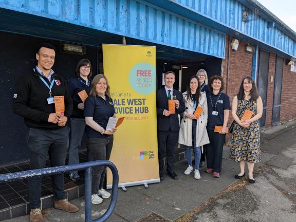 Photo of eight representatives from Trafford Council and the community stood outside Sale West Community Hub