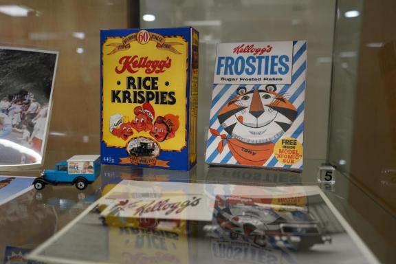 Vintage Kellogg’s cereal display in a glass case, featuring a bright yellow Rice Krispies “Diamond Jubilee 1928–1988” box with Snap, Crackle, and Pop illustrations, alongside a classic Frosties box with Tony the Tiger.