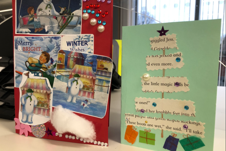 Two handmade Christmas cards on display in a library