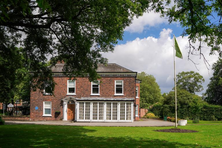 Flixton House, a Georgian brick building, appears betwen some trees