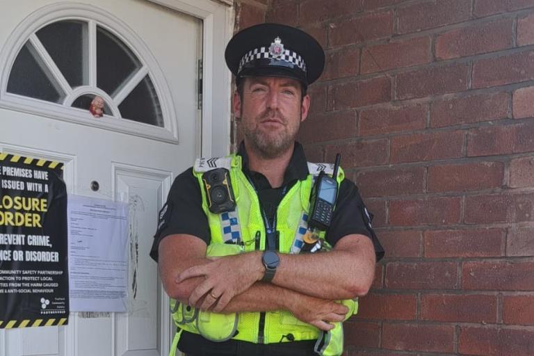Police officer outside closed house